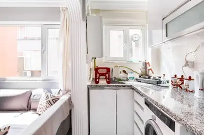 a white kitchen with white cabinets and a sink at Practical and Cozy Flat Near Taksim İstikal in Istanbul
