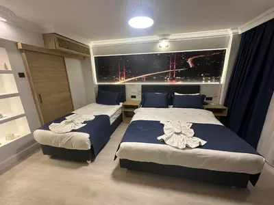 a hotel room with two beds with blue and white sheets at Bella Otel Mudanya in Mudanya