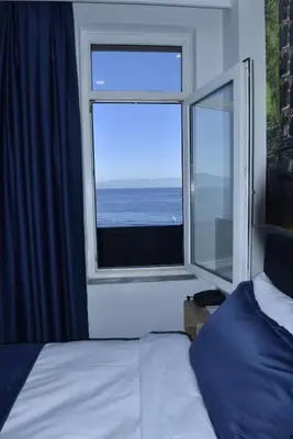 a bedroom with a window with a view of the ocean at Bella Otel Mudanya in Mudanya
