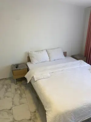 a bedroom with a white bed and a side table at YENİkapı in Istanbul