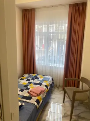 a bedroom with a bed and a window and a chair at YENİkapı in Istanbul