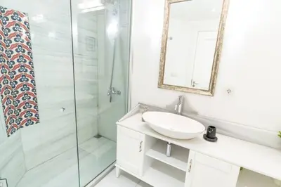 a white bathroom with a sink and a shower at Stylish Duplex in Beyoğlu with Private Terrace in Istanbul