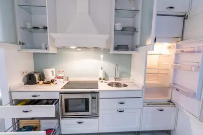 a kitchen with white cabinets and a sink and a refrigerator at Cozy Getaway - Warmth and Comfort in the City in Istanbul