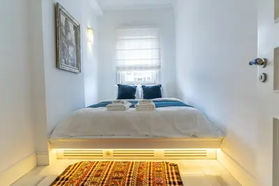 a bedroom with a bed with a window and a rug at Cozy Getaway - Warmth and Comfort in the City in Istanbul