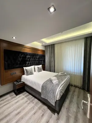 a bedroom with a large bed and a large window at Golden Stoneluxe İstanbul Hotel in Istanbul