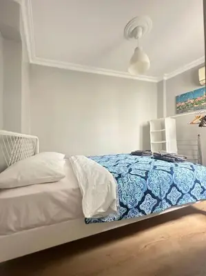 a bedroom with a bed with a blue and white blanket at 5 Min Walk Distance Taksim Square Semi Sea View in Istanbul