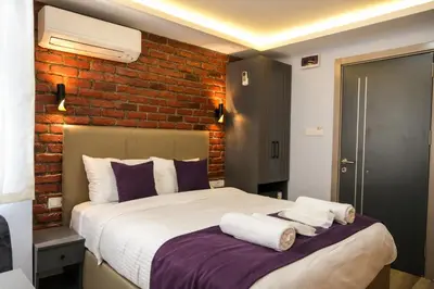 a bedroom with a large bed with a brick wall at Yellow Mansion in Istanbul