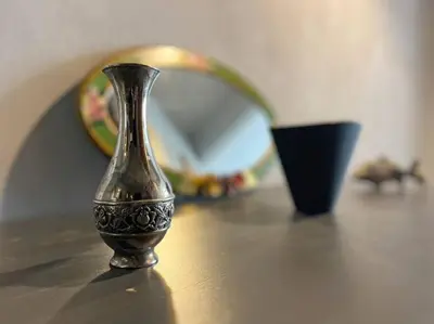 a vase sitting on a table next to a mirror at Central & cosy flat for 4 Person in Istanbul