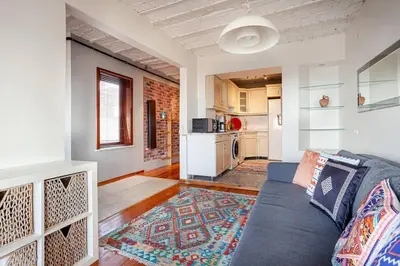 a living room with a blue couch and a kitchen at Magnificent view, in the center in Istanbul