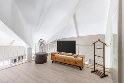 a living room with a flat screen tv in an attic at Beautiful Bright Cool Modern 1BD Balat Loft! #329 in Istanbul