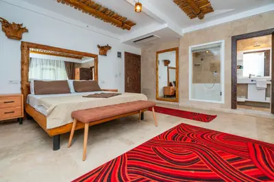a bedroom with a large bed and a red rug at PASHA PALACE HOTEL in Istanbul