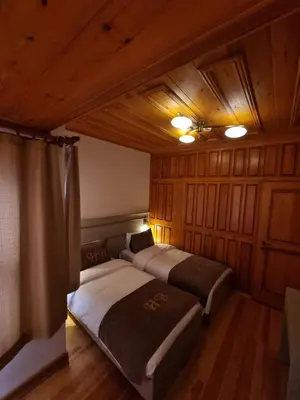 two beds in a room with wooden walls and ceilings at HaciBayramApart in Istanbul