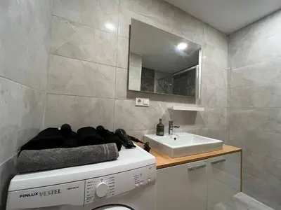 a bathroom with a sink and a washing machine at Cozy Home 1 Room 1 Living Room Apartment in Esenyurt