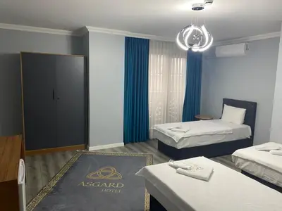 a hotel room with two beds and a door at Asgard Hotel in Beylikduzu