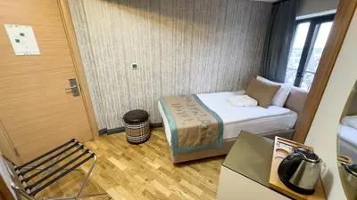 a small room with a bed and a chair at Avcı Palace Hotel in Istanbul