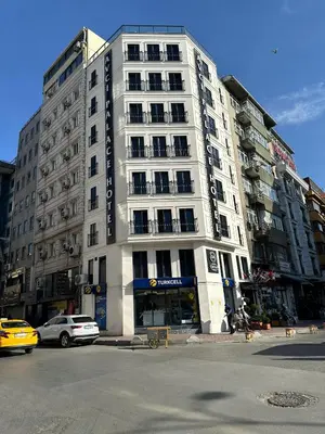 a tall white building with a car parked in front of it at Avcı Palace Hotel in Istanbul