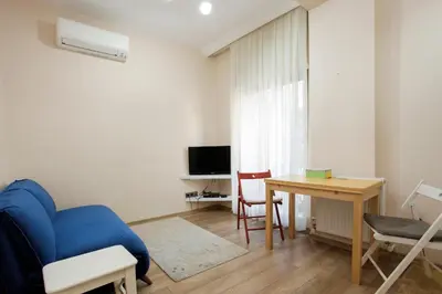 a living room with a blue couch and a table at Stay Juno in Istanbul