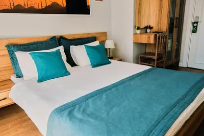 a bedroom with a large bed with blue and white pillows at Taksim Santa Lucia Hotel in Istanbul