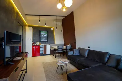 a living room with a black couch and a kitchen at Lake Look Sapanca in Sapanca