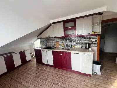 a kitchen with white and red cabinets in a room at Airport Confort Guest House in Arnavutköy