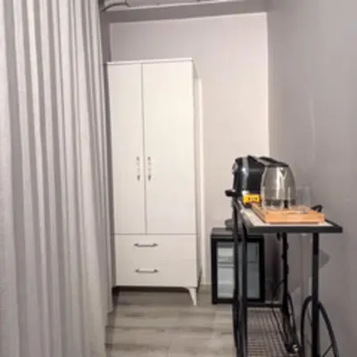 a white cabinet in a room with a table at Galata Inn Hotel in Istanbul