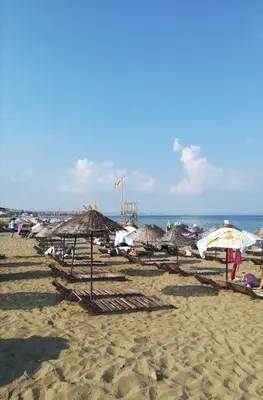 a beach with umbrellas and chairs and the ocean at The rooms hotel in Kumbağ