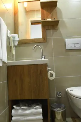 a bathroom with a sink and a toilet and a mirror at Cibali Hotel Istanbul in Istanbul