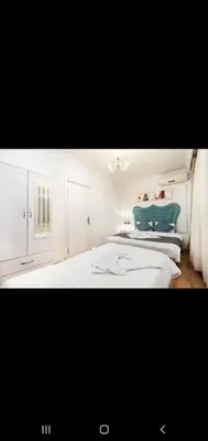 a white bedroom with two beds and a green couch at 3 FLOOR OLD CITY 1 in Istanbul