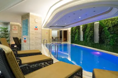 a swimming pool in a building with chairs around it at Felicity Hotel İstanbul in Istanbul