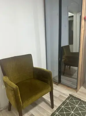 a green chair sitting in a room with a mirror at Taksim Cihangir'de 2+1 daire in Istanbul
