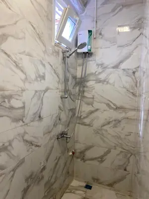 a bathroom with a shower with white marble walls at YENİKAPI hotel in Istanbul