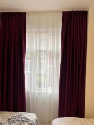 a bedroom with a window with red curtains at YeniKAPI in Istanbul