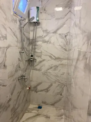 a bathroom with a shower with white marble walls at YeniKAPI in Istanbul