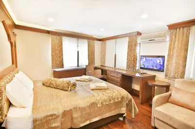 a bedroom with a bed and a desk and a television at Kumluk Konak Hotel in Istanbul