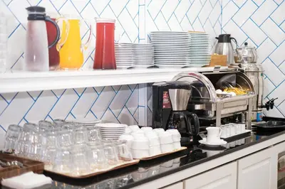 a kitchen counter with plates and cups and a coffee maker at Istanbul Old City Sultanahmed Miran Hotel in Istanbul