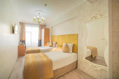 a hotel room with two beds and a chandelier at Istanbul Old City Sultanahmed Miran Hotel in Istanbul