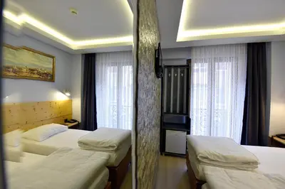 a hotel room with two beds and two windows at Sunlife Oldcity in Istanbul