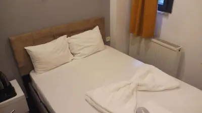 a bed with white sheets and pillows in a room at happy apart hotel istanbul in Istanbul