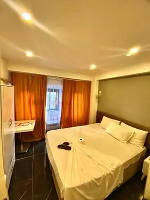 a bedroom with a large white bed with orange curtains at happy apart hotel istanbul in Istanbul
