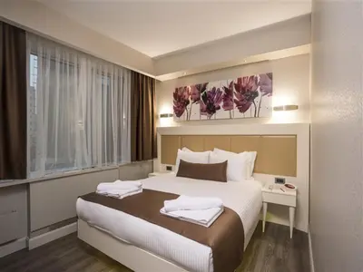 a hotel room with a large bed and a window at Bilek Hotel Kavacık in Istanbul