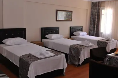a room with three beds with white sheets at Emsa Otel Maltepedeki Eviniz in Istanbul