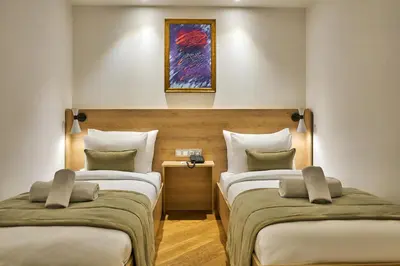 two beds in a room with a painting on the wall at Joyway Hotels Istanbul Sultanahmet in Istanbul