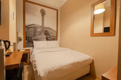 a bedroom with a bed and a desk with a picture at Sisli MLS Hotel in Istanbul
