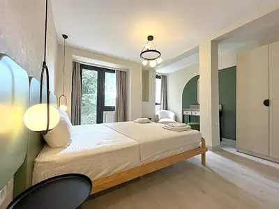 a bedroom with a large bed with two chairs at Flex Ortakoy in Istanbul