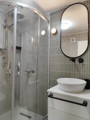 a bathroom with a sink and a shower with a mirror at Flex Ortakoy in Istanbul