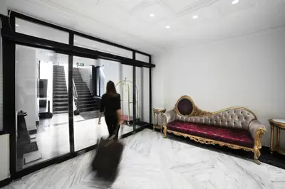 a woman walking through a room with a couch at White Monarch Hotel in Istanbul