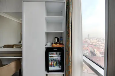 a room with a drink cooler in a room with a window at White Monarch Hotel in Istanbul