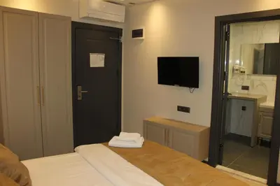 a bedroom with a bed and a tv on the wall at Eyüp Sultan Palace Hotel in Istanbul