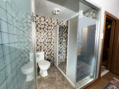a bathroom with a toilet and a glass shower at The New Season Apart in Istanbul