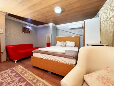 a bedroom with a bed and a red chair at The New Season Apart in Istanbul